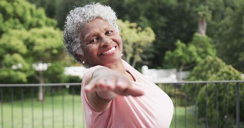 Happy Senior Woman Practicing Yoga Outdoors with Joyful Smile