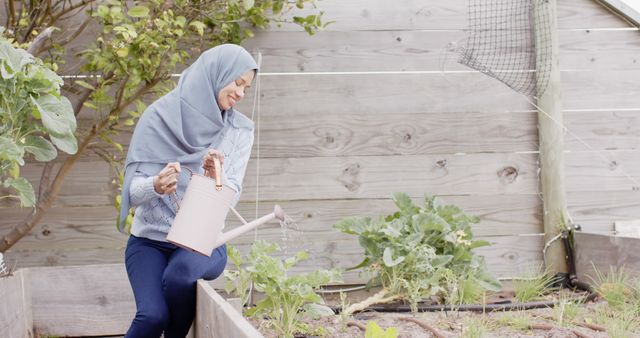 Muslim Woman in Hijab Watering Garden Plants - Download Free Stock Images Pikwizard.com