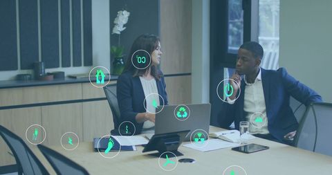 Diverse Colleagues Using Laptop with Ecology Icons in Office