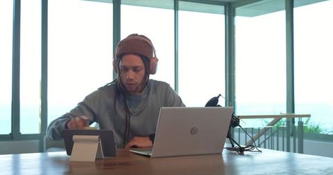 African american creator recording podcast at waterfront workspace with laptop and tablet