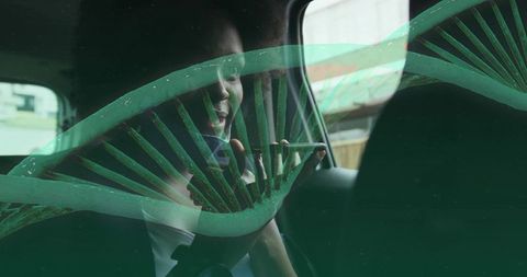Smiling woman speaking into smartphone in rear car seat with green dna helix overlay