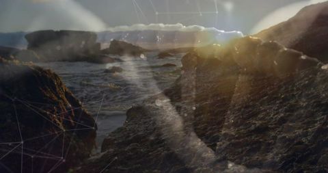 Moody basalt shoreline at low sun with lens flare and abstract network node overlay
