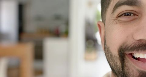 Smiling bearded indian man closeup half-face portrait in home kitchen natural light