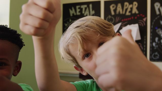 Children wear green shirts with recycling logos, showing thumbs up and smiling to promote ecological responsibility and environmental education. Suitable for use in campaigns on sustainability, educational materials or resources that emphasize recycling, and blogs focusing on environmental issues. Expresses positivity and eagerness among youngsters to embrace sustainable habits.