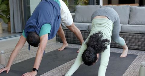Couple Practicing Yoga in Downward Dog Pose on Patio