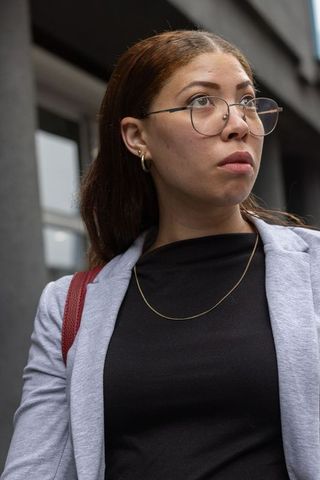 African american professional woman looking up outside office building
