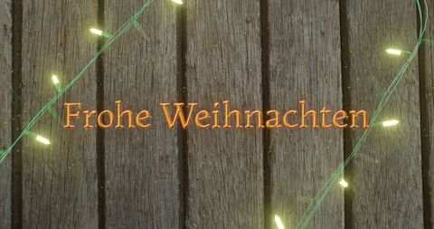 Frohe Weihnachten Text with Festive Fairy Lights on Wooden Background