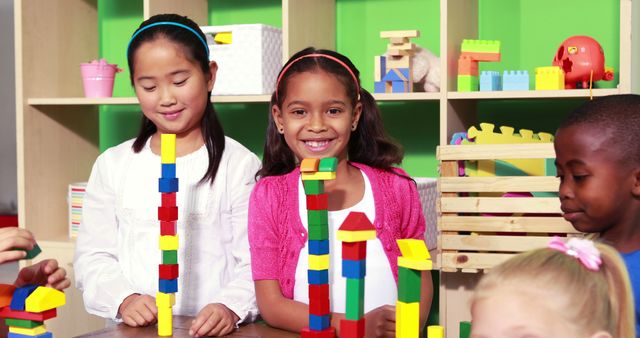 Children from various backgrounds building towers with colorful blocks indoors in a bright classroom. Smiling faces and teamwork make this a great image for educational purposes, promoting diversity and inclusivity, or showing playful learning environments.