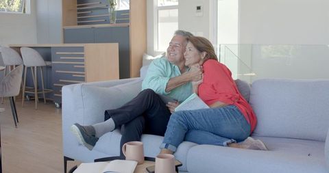 Senior Couple High-Fiving on Sofa, Sharing Joyful Companionship
