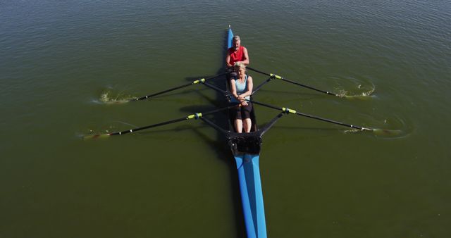 Senior caucasian man and woman rowing boat on a river. sport retirement leisure hobbies rowing healthy outdoor lifestyle.