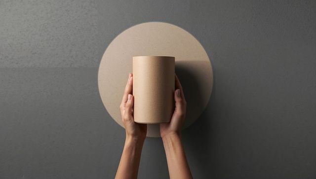 Hands Holding Cylindrical Cardboard Cover Faded Design Background