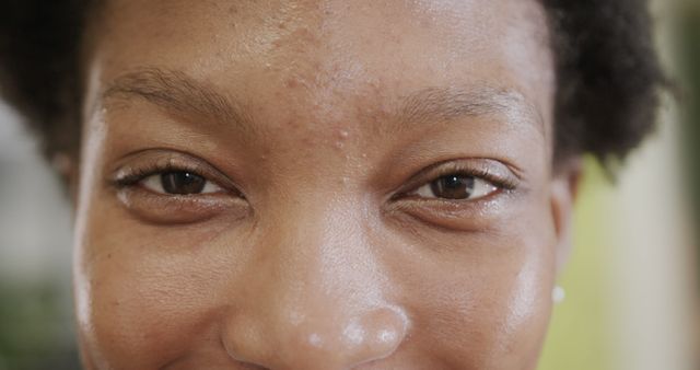 Close up of eyes of happy african american casual businesswoman smiling on office. Casual business, work and office, unaltered.