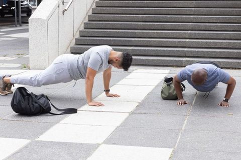 African american men doing push-ups on urban plaza steps outdoor partner fitness training