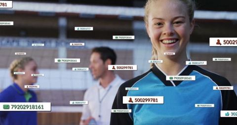 Smiling volleyball player in gym with digital overlays of ids