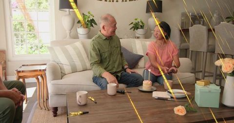 Senior couple sharing birthday cake in cozy living room celebration