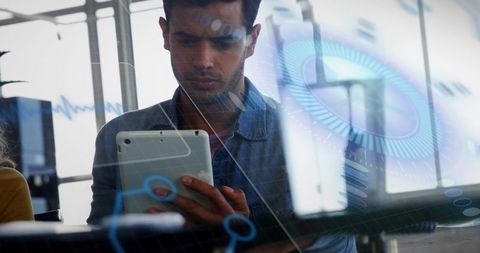 Man examining tablet with holographic tools in office setting