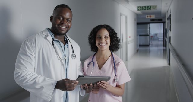 Diverse medical professionals discussing patient records in hospital corridor - Download Free Stock Images Pikwizard.com