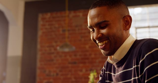 Laughing Young Man in Striped Sweater in Cozy Brick Interior - Download Free Stock Images Pikwizard.com