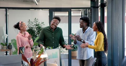 Diverse Team Enthusiastically Collaborating in Modern Office Space