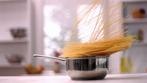 Spaghetti Dramatically Falling into Pot in Modern Kitchen