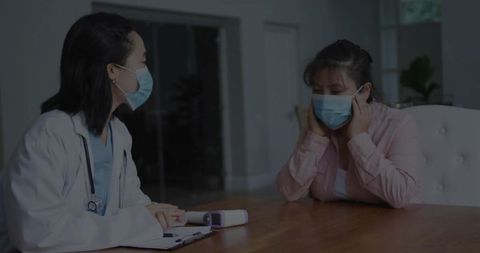 Doctor consults with female patient in medical setting