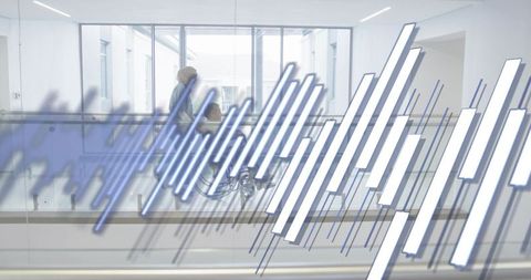 Caregiver pushing senior wheelchair through modern medical atrium with digital data overlay