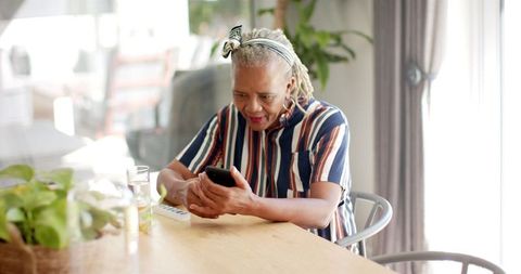 Senior Woman Engaging with Smartphone in Home Setting