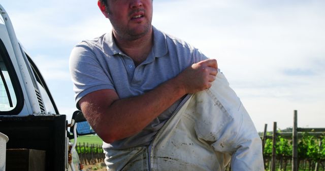 Farmer Putting on Protective Gear Near Vineyard - Download Free Stock Images Pikwizard.com