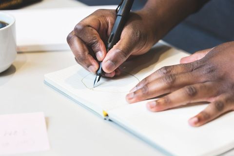Close-up of Person's Hands Onto Notebook for Creative Art