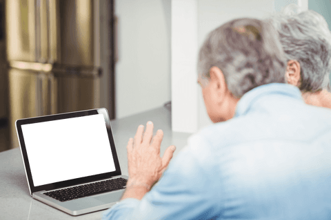 Senior Couple Using Laptop with Blank Transparent Screen