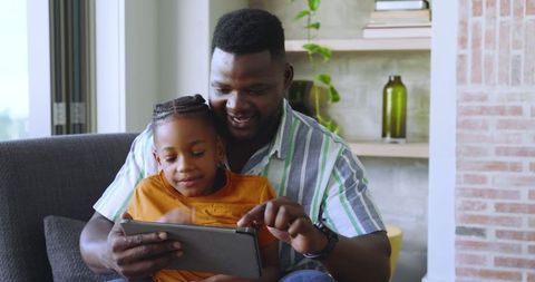 Father and Son Bonding over Tablet in Cozy Living Room