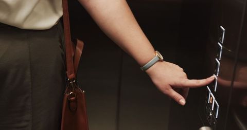 Person Using Elevator Buttons While Checking Wristwatch
