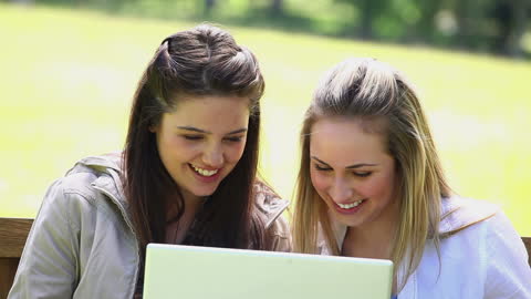 Two Friends Collaborating on Laptop Outdoors