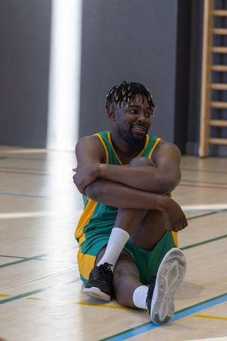 Basketball Player Relaxing in Gym in Bright Uniform