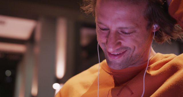 Young Man Smiling While Listening to Music with Earphones Indoors - Download Free Stock Images Pikwizard.com