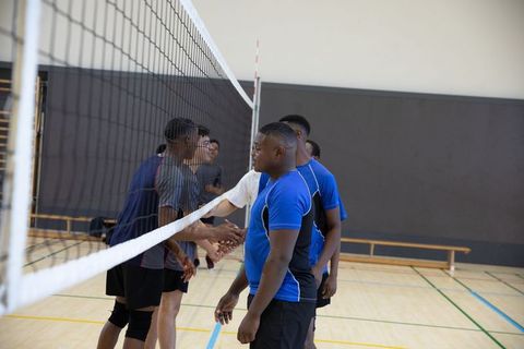 African american teen volleyball team exchanging handshakes demonstrating sportsmanship
