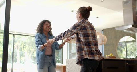 Diverse Friends Joyfully Dancing in Modern Kitchen