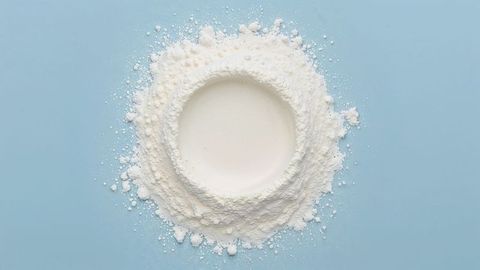 Creative circle of white milk powder on blue background