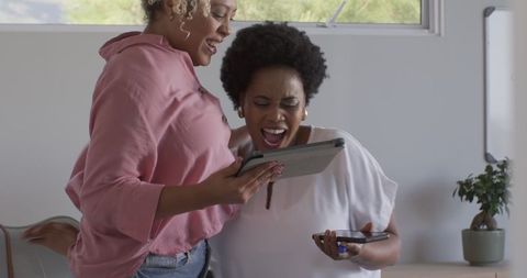 Excited businesswomen collaborating in modern office setting