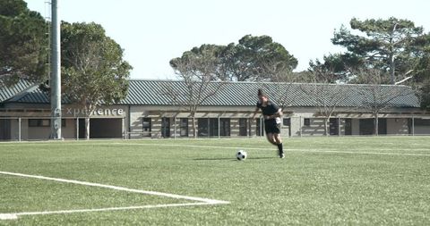 Confident Soccer Player Preparing to Kick Ball on Sunny Field
