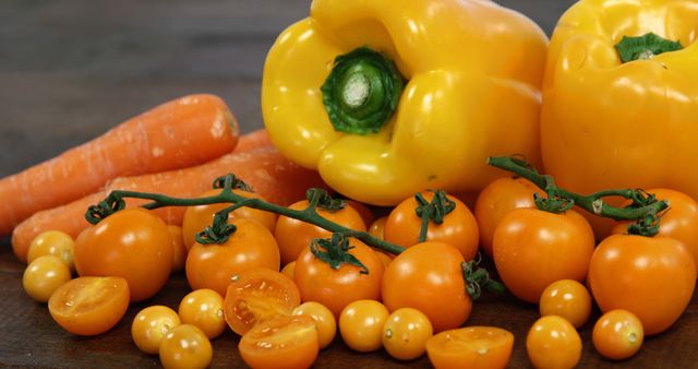 Close-up of Fresh Yellow Bell Peppers, Tomatoes, and Carrots on Wooden Surface - Download Free Stock Images Pikwizard.com