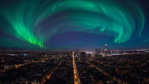 Green Aurora Borealis Dancing Over Modern City Skyline and Illuminated Avenue