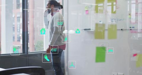 Businessman talking on phone in modern office with ar sustainability icons and sticky notes