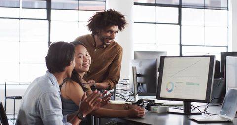 Colleagues Collaborating Enthusiastically in Modern Office
