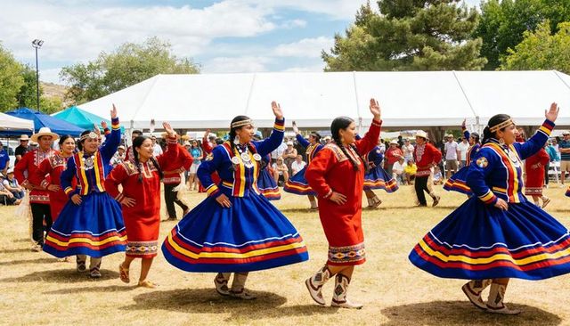 Women performing traditional skirt dance in vibrant regalia at outdoor cultural festival