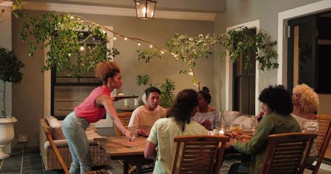 Friends Having Conversation After Dinner Party Under Warm Lights