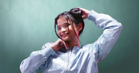 Smiling woman posing confidently in trendy metallic bomber jacket