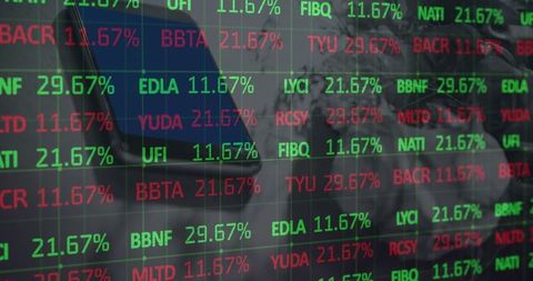 Stock market data displayed on screen with smartphone reflection