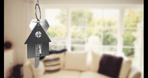 Silver House Key Over Bright Living Room Background