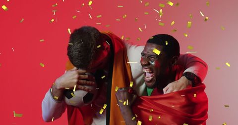 Diverse male supporters celebrating sports victory confetti